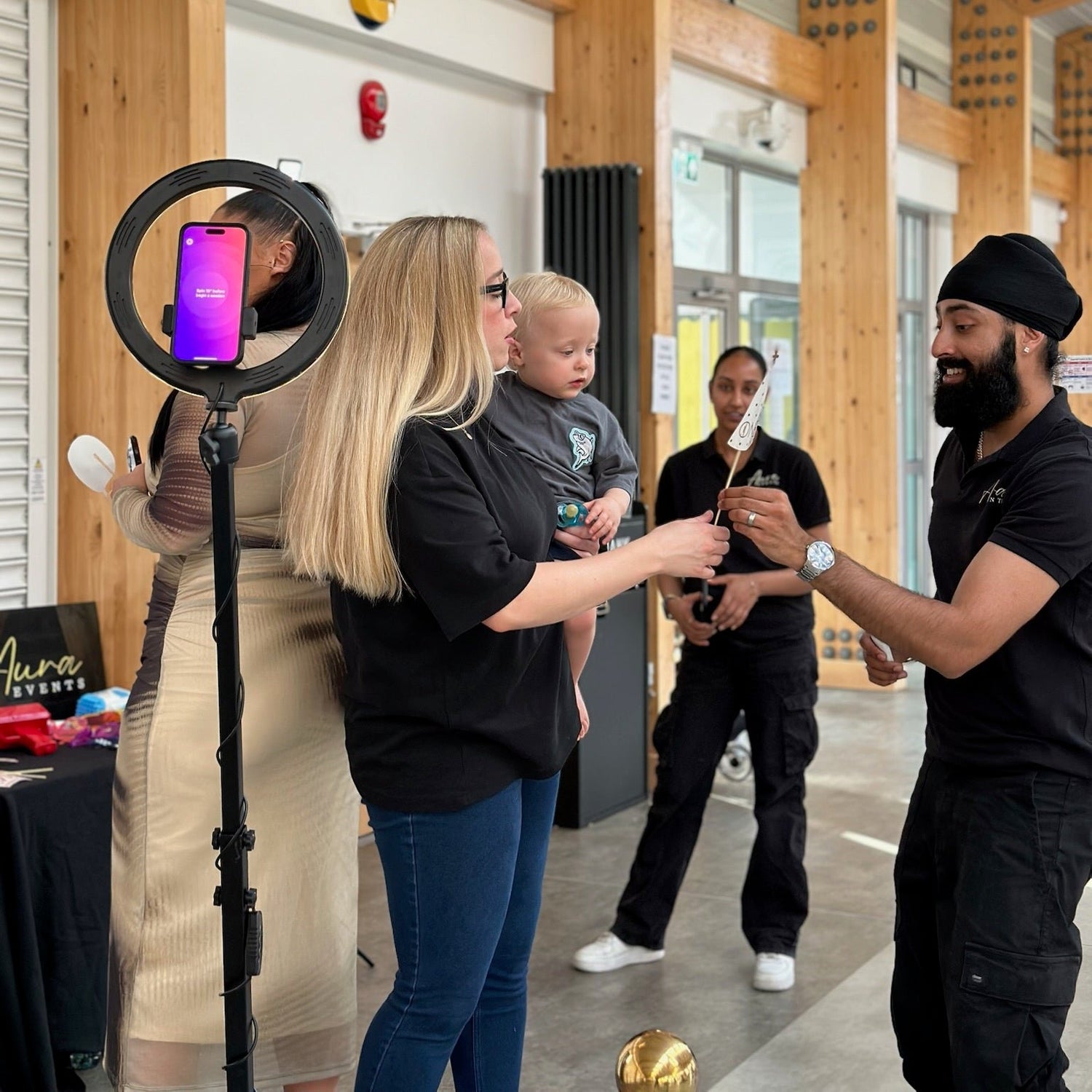 Aura Events booth attendants at a party in london passing a guest props